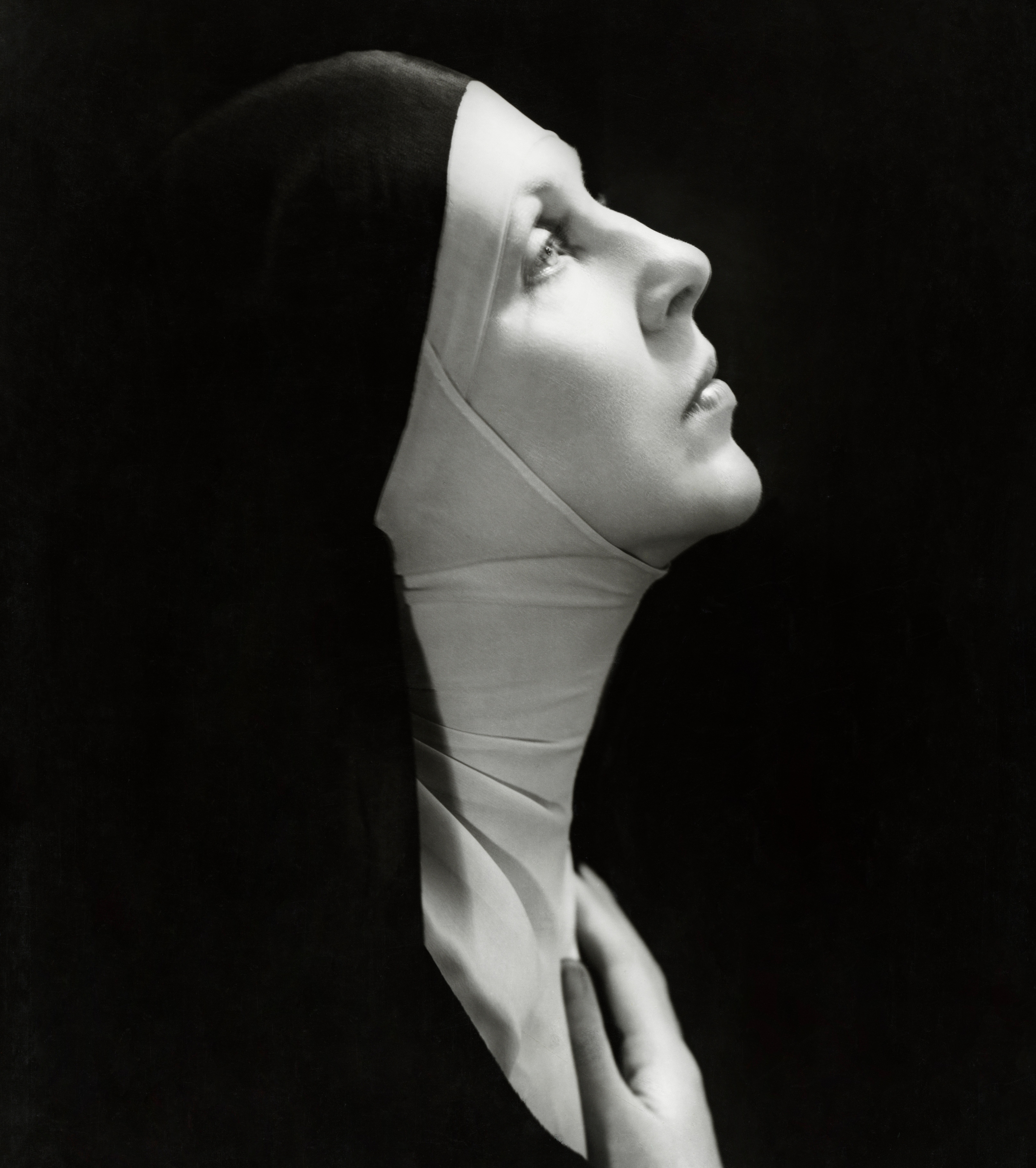 Lady Diana Cooper as The Nun in The Miracle, looking upward with her hand to her chest.