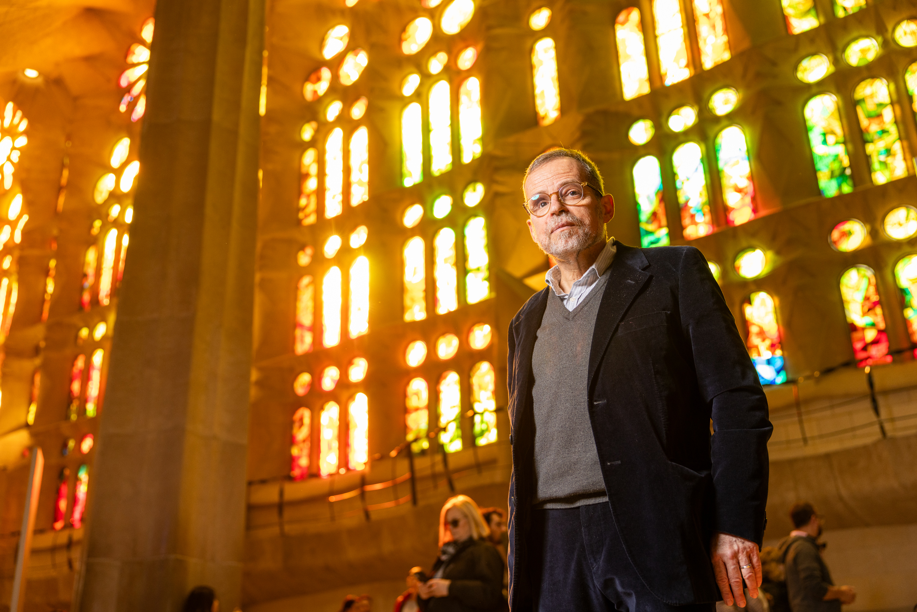 Jordi Faulí, head architect of the Sagrada Família, standing before the basilica's stained glass windows.