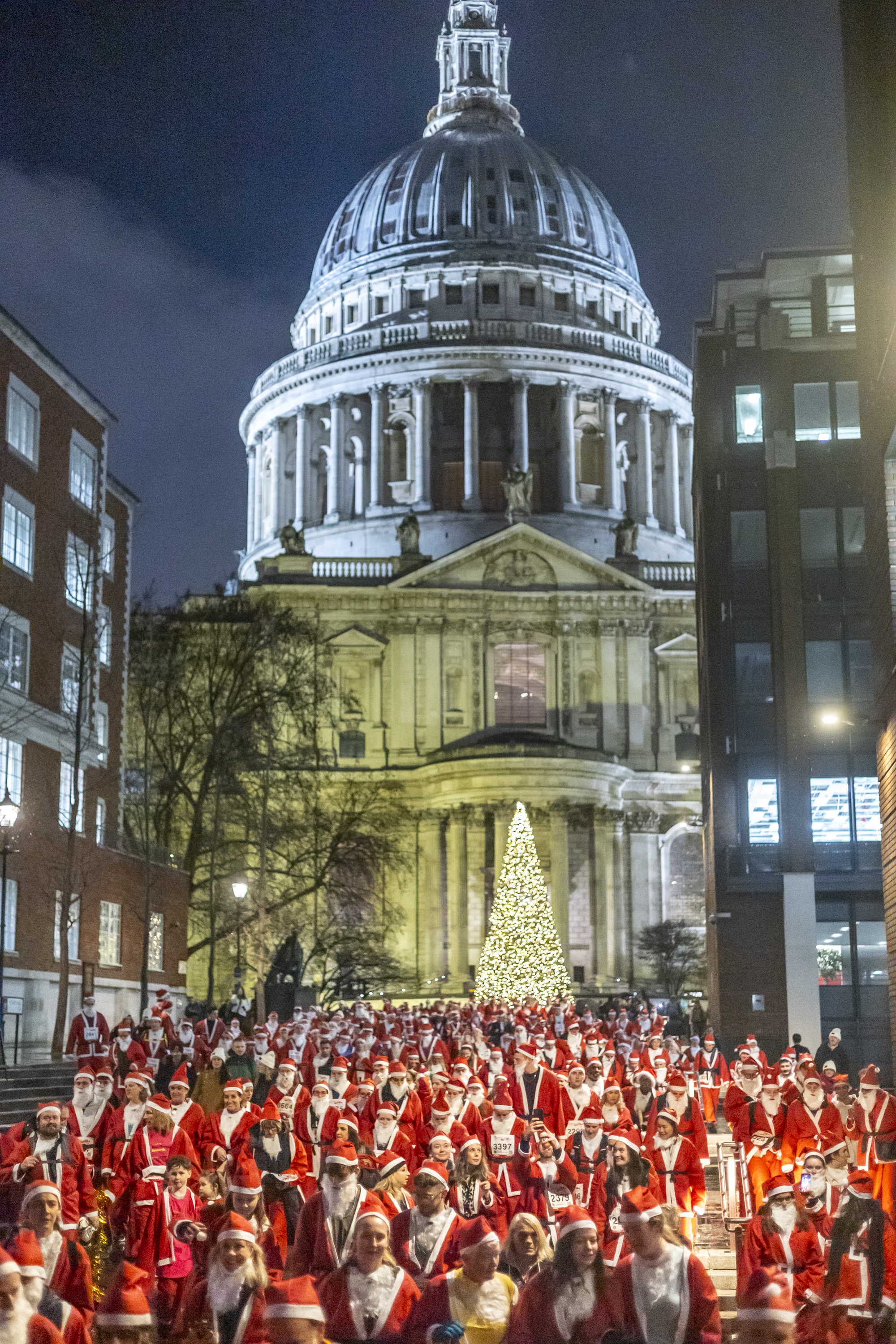 Participants in Santa Claus costumes take part in a 4.5 km Santa Dash in front of St. Paul’s Cathedral.