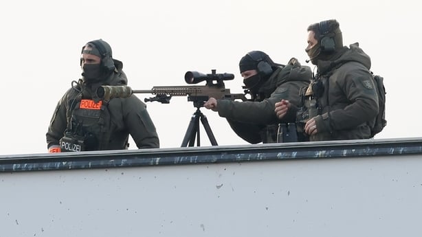A police sniper team stands on the roof of the Chancellery prior to the arrival of U.S. negotiators in Berlin