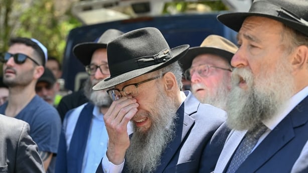 A mourner weeps as he follows the hearse carrying the coffin of rabbi Eli Schlanger, who was killed in the December 14 Bondi beach shooting attack, after his funeral service at the Chabad of Bondi Synagogue in Sydney on December 17, 2025. Australia held the first funeral on December 17 for victims o