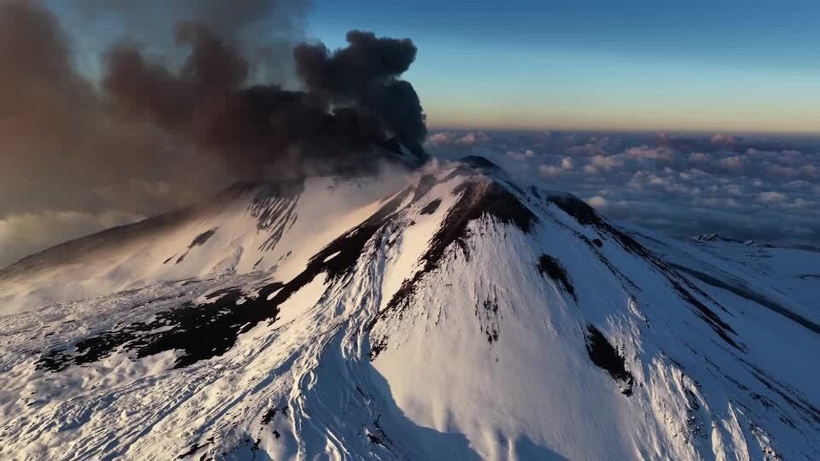 Skiers glide down slopes as Mount Etna erupts