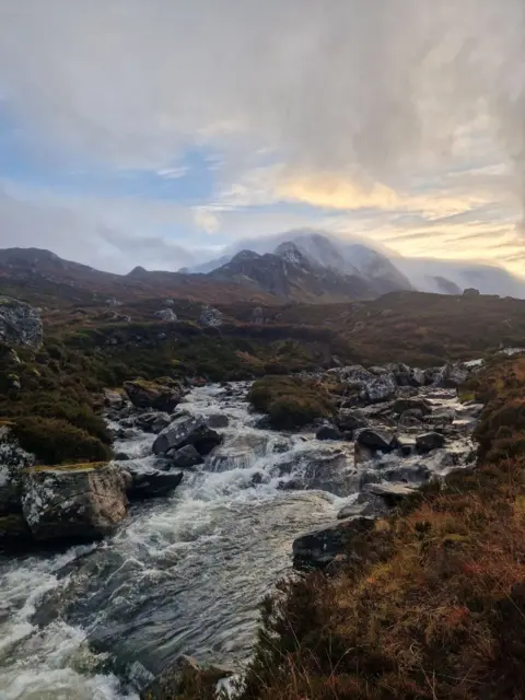Ryan Cuthbert A snow-capped mountain with a body of water in the foreground