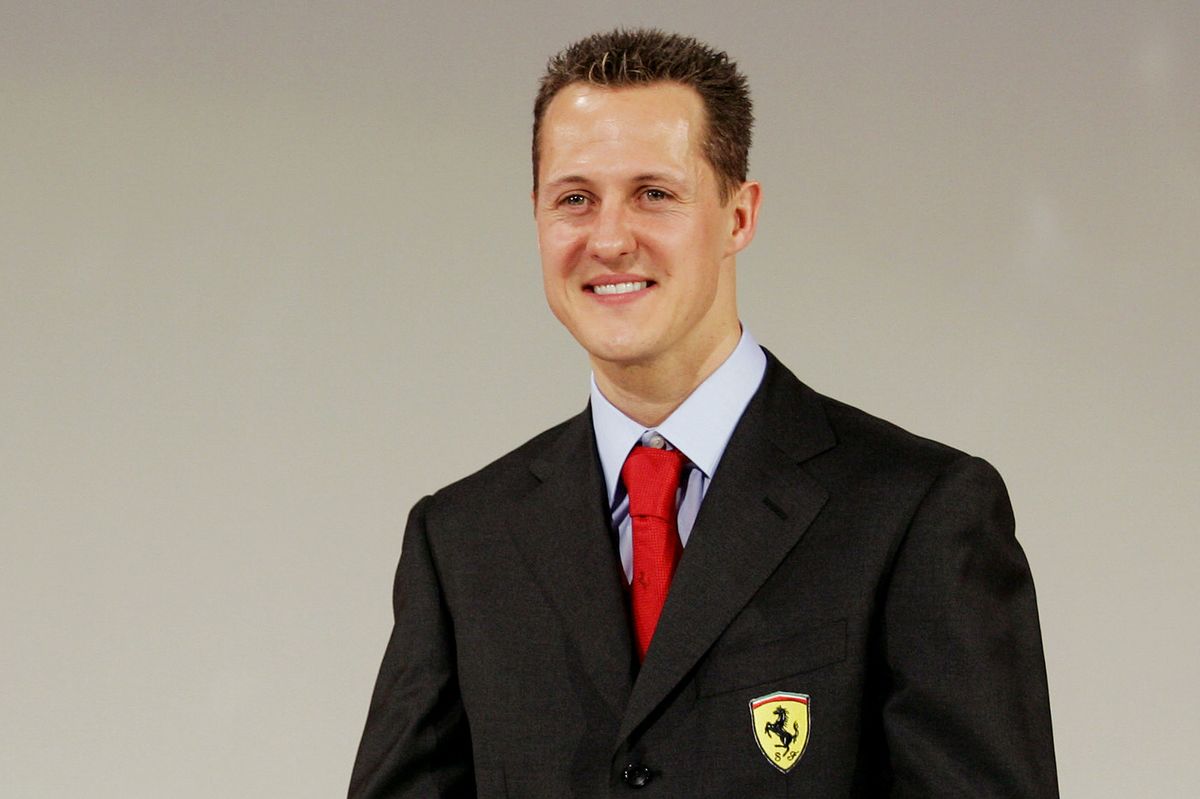 Michael Schumacher smiles as he poses with the Ferrari F2005 F1 car during an official presentation