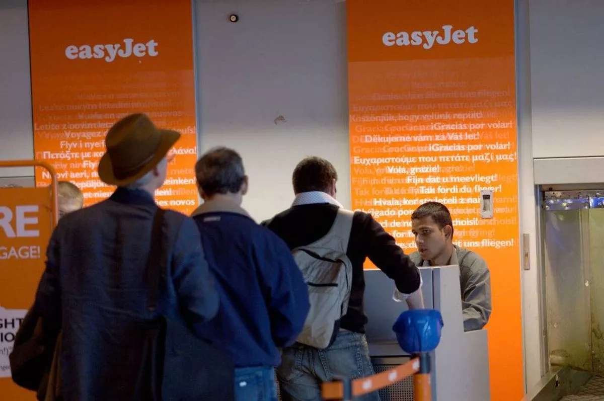 easyJet check-in queue with businessmen in suits with carry-on baggage