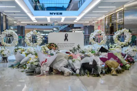 Getty Bouquets and wreaths of flowers in a shopping centre with a Myer sign in the background