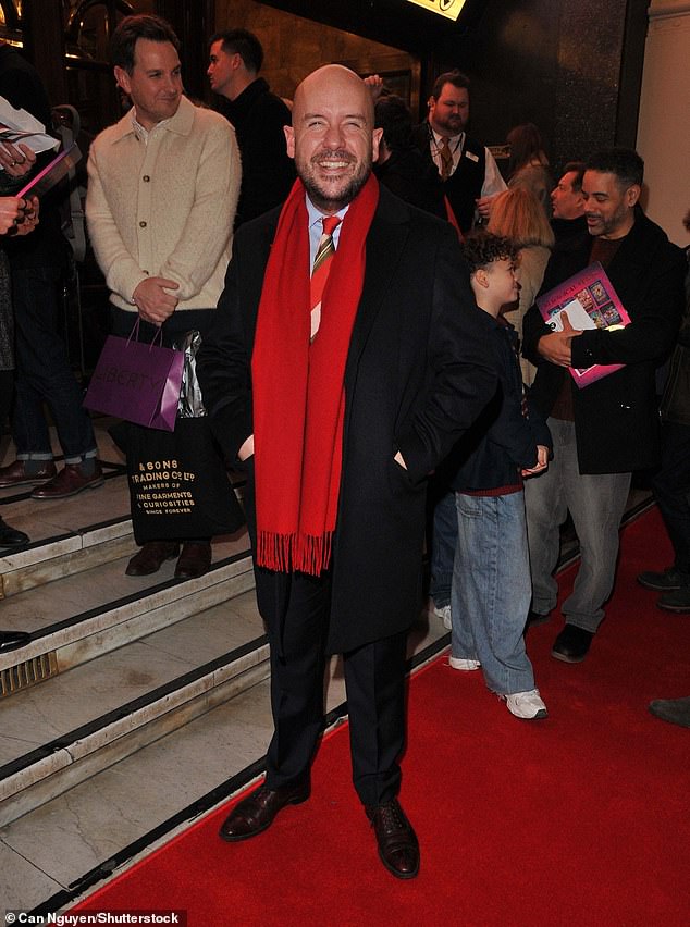 Tom Allen dressed smart in a suit complete with a red scarf