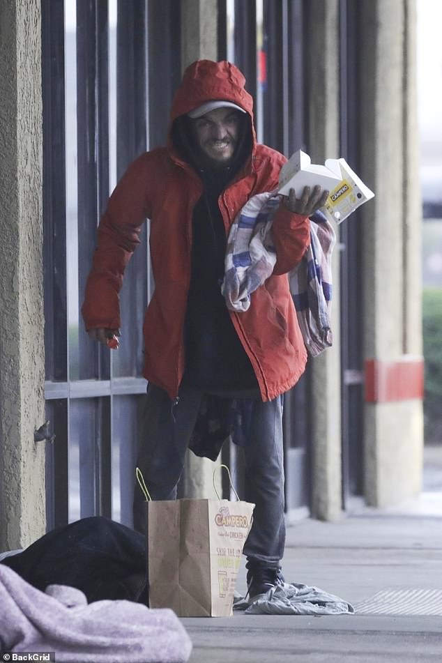 Former Nickelodeon child star Tylor Chase is now receiving medical care after shocking fans with viral videos of him living on the street, the Daily Mail has learned; pictured Wednesday on a rainy Christmas Eve in Southern California