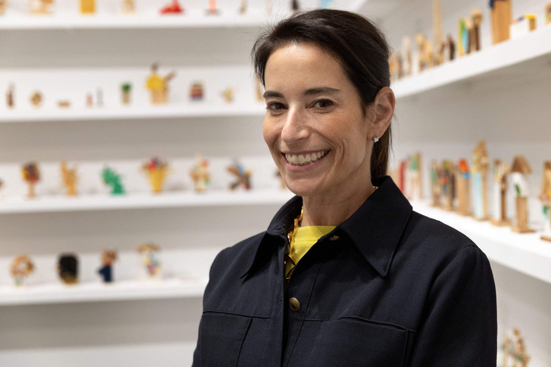 ICA director Nora Burnett Abrams in a gallery lined with small sculptures by Milton artist Damien Hoar de Galvan. (Robin Lubbock/WBUR)