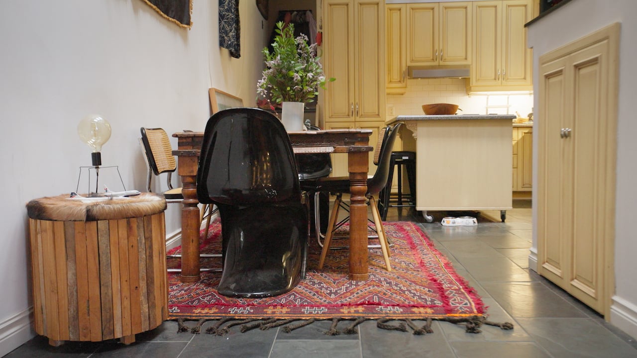A dining table and chairs next to a wall in the kitchen. 