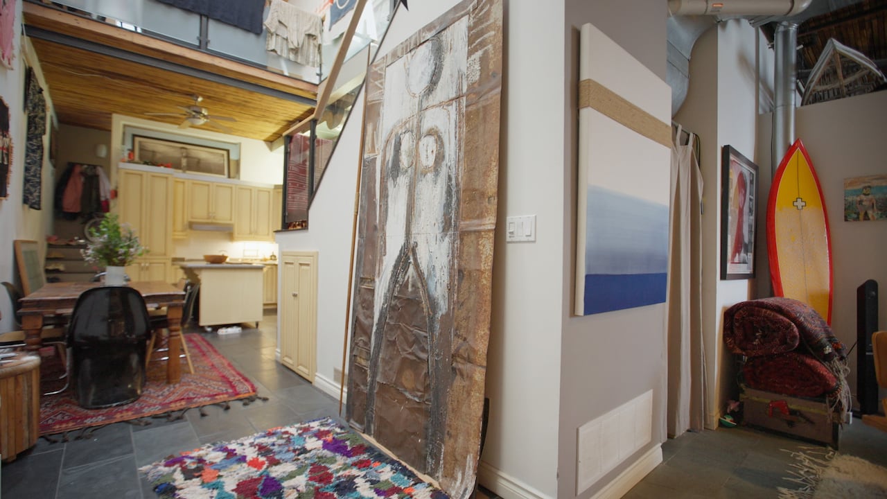 A large painting stands against a wall next to the kitchen. 