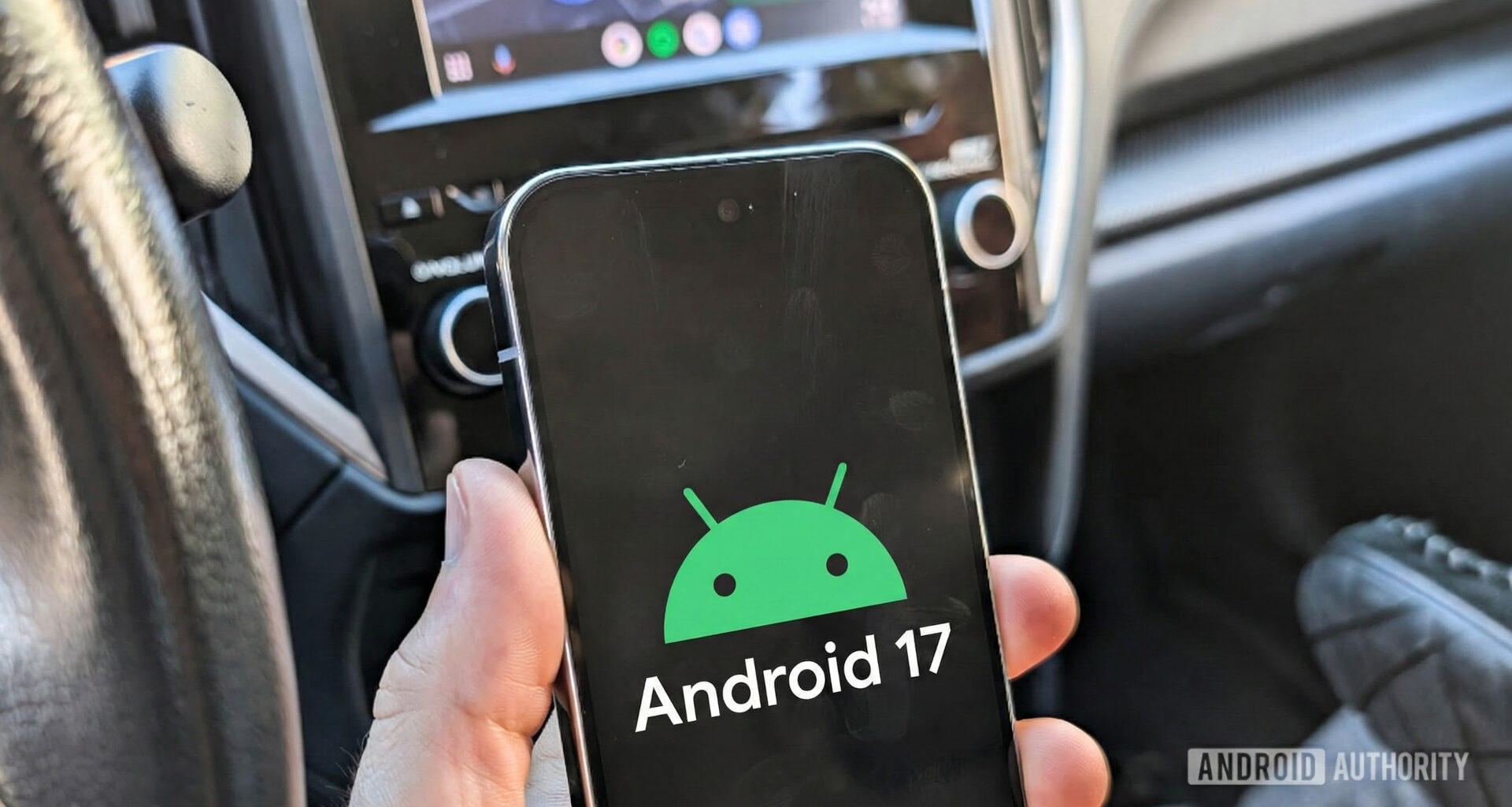 Android 17 logo on a Pixel phone held in a car 2
