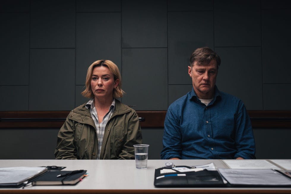 two individuals seated at a table in a room accompanied by various documents two individuals seated at a table in a room accompanied by various documents