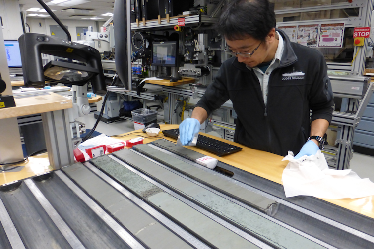 A person looks at long gray strips of rock.