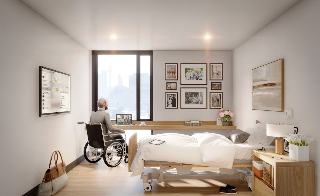 A rendering of the room design at the Rekai Centre's Cherry Place. A man is depicted sitting at a desk by a window. The room features a bed, picture frames and storage space. 