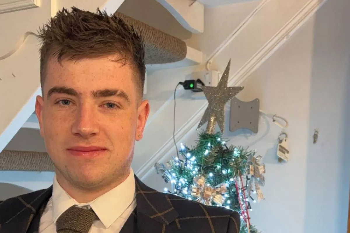 A family photograph of Shea McCabe wearing a suit with a Christmas tree in the background