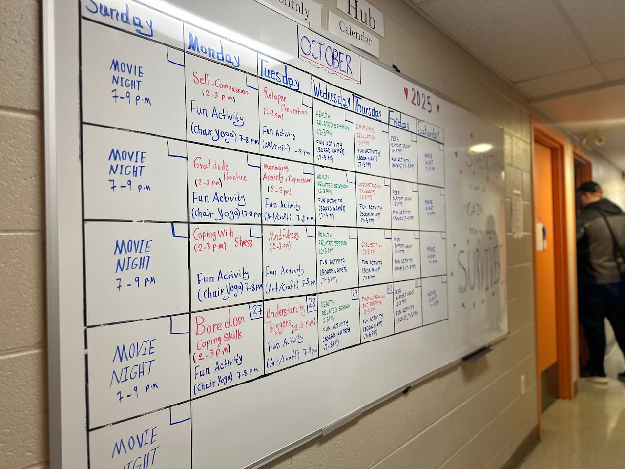 An activity board for the month of October on a white board includes movie night on Sundays and activities such as boredom coping skills, gratitude practice, understanding triggers and relapse prevention. 