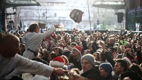 Getty Images Workers sell off cuts of meat during the traditional Christmas Eve auction at Smithfield meat market in London, UK on 24 December 2025.