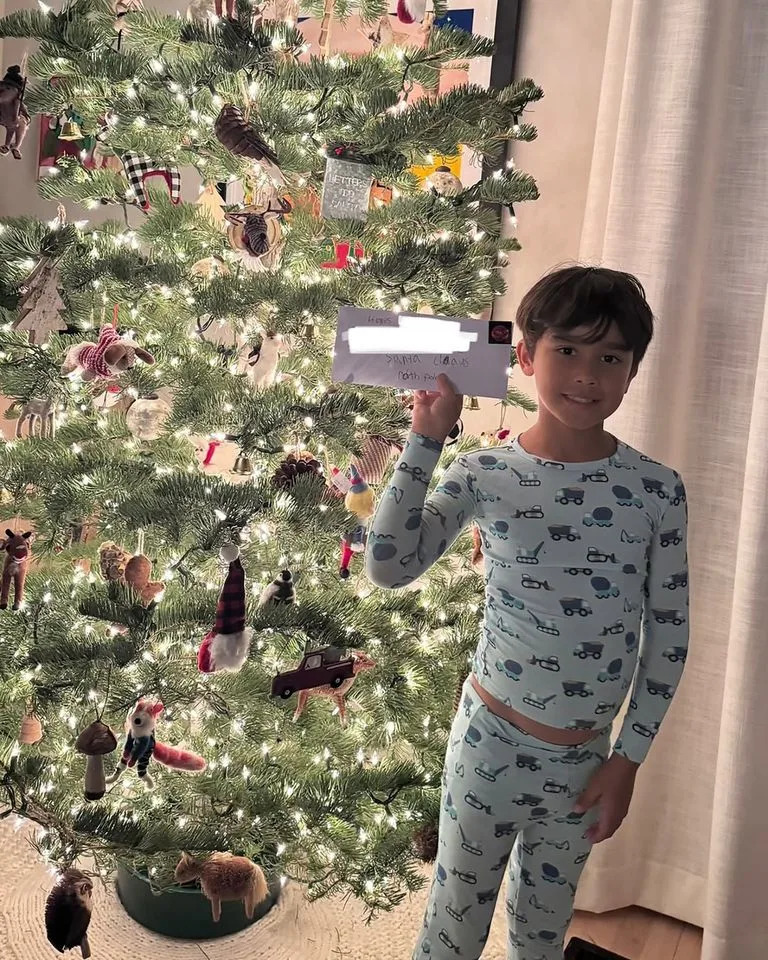 Jessica Alba/Instagram Hayes holds up his letter to Santa by the tree.