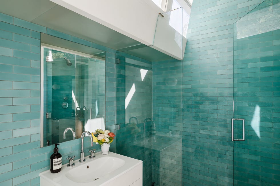 Modern bathroom featuring turquoise tiles and glass shower enclosure