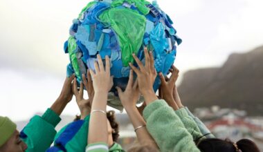 A group of people holding up an artwork of the Earth made of waste