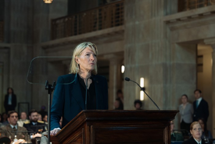 Jemma Redgrave as Kate Lethbridge Stewart in The War Between The Land And The Sea, stood at a podium.
