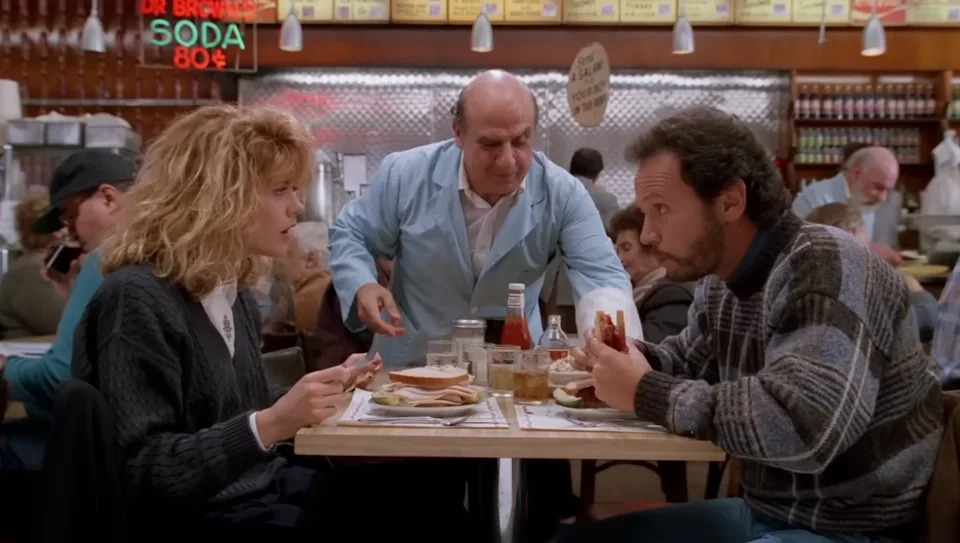 A restaurant scene with a waitress taking orders from a man and woman at a diner table, featuring bustling background patrons