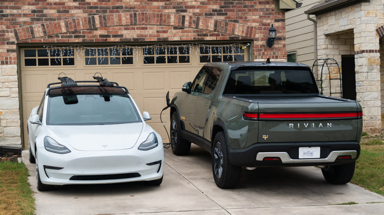 Tesla and Rivian cars parked in home driveway