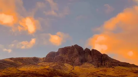 Lavanya Kashyap A mountain bathed in red light from the sunset