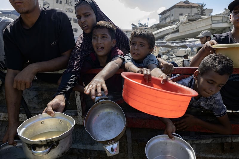 Palestinians pleading for food at a charity kitchen in Gaza City in August. Photograph: Saher Alghorra/The New York Times