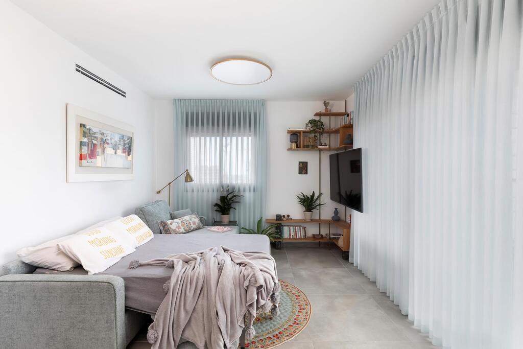 A small apartment with a sofa that opens into a guest bed (Photo: Merav Felberg) דירה קטנה בבת ים, עיצוב: חגית חסון