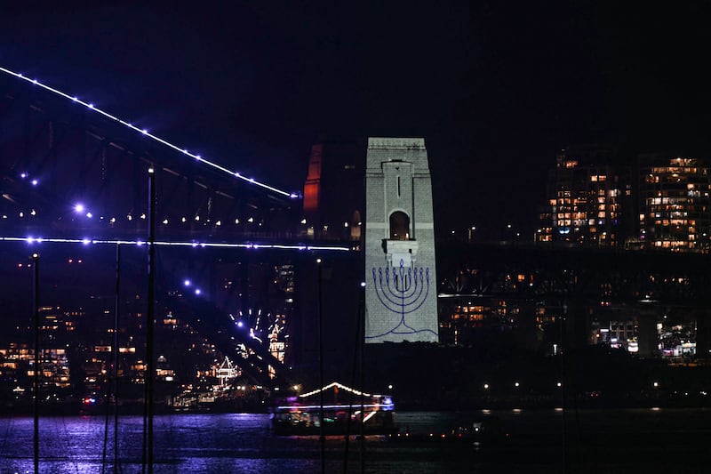 The figure of a menorah is displayed on the pylon of the Sydney Harbour Bridge to reflect on the tragic Bondi Beach shooting attack before New Year's Eve midnight fireworks display in Sydney on December 31, 2025. (Photo by Saeed KHAN / AFP via Getty Images)