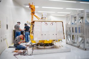 Orlando Abeyta works on wiring prior to placing a cage around and attaching the VIPER rover to the arm of the Superfuge at Sandia National Laboratories. (Photo by Craig Fritz) Click on the thumbnail for a high-resolution image. 