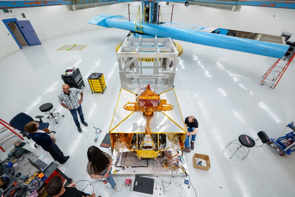 Karen Rogers, left, Orlando Abeyta and Leticia Mercado discuss the testing of the VIPER rover at the Superfuge, while Chad Heitman, right, works on sensors for the test at Sandia National Laboratories. (Photo by Craig Fritz) Click on the thumbnail for a high-resolution image.