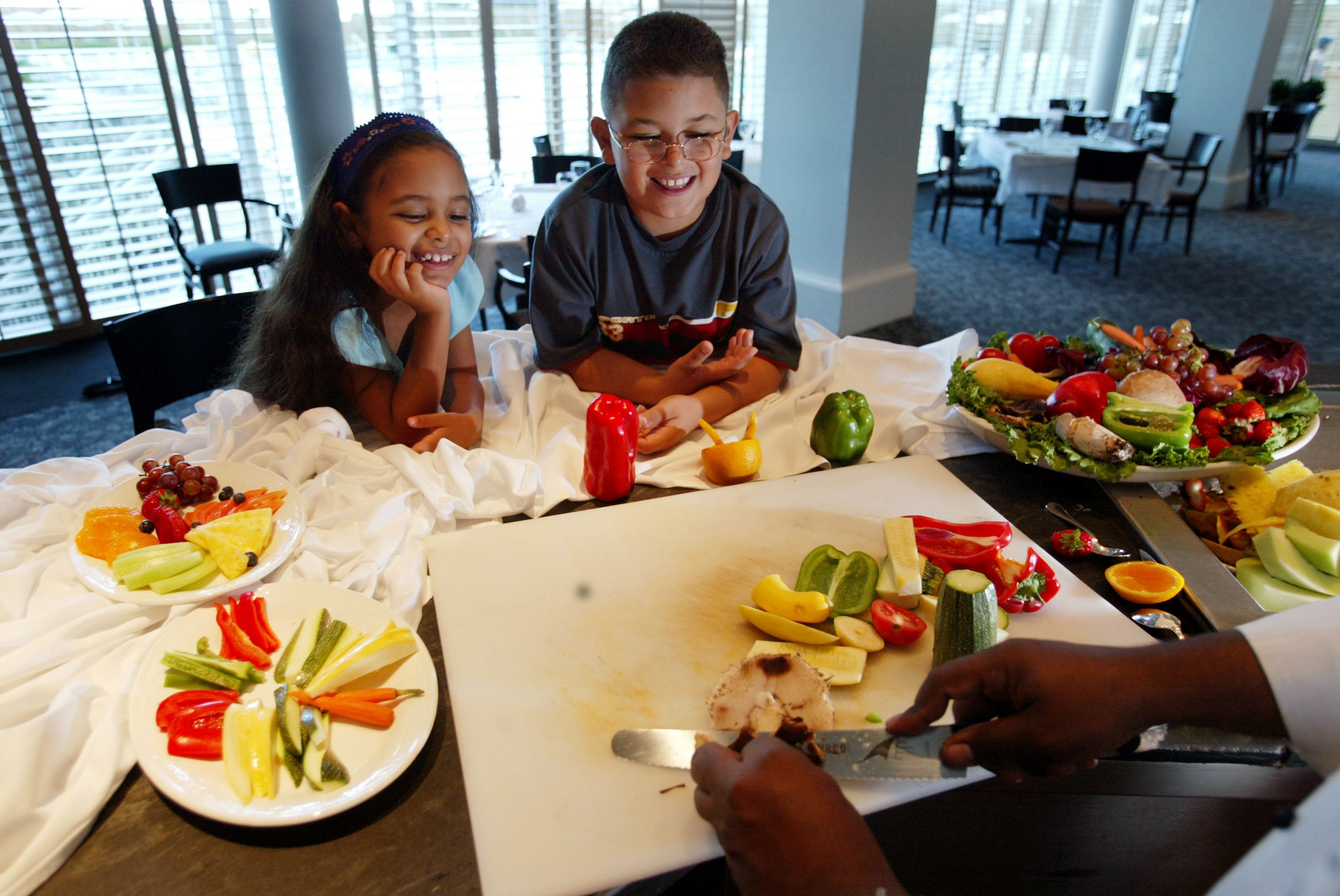 Siblings watch a chef prepare a healthy snack of fruits and vegetables in July 2002 in Miami Beach, Florida. Children who eat vegan and vegetarian diets are low on some key nutrients, according to a large new study
