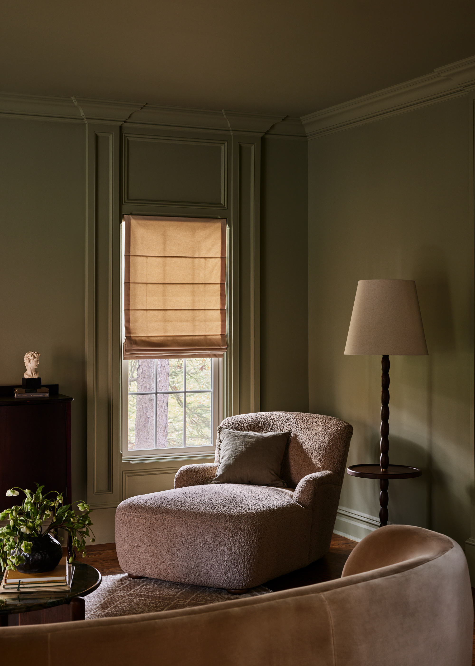 A sage green living room with pale pink sofas