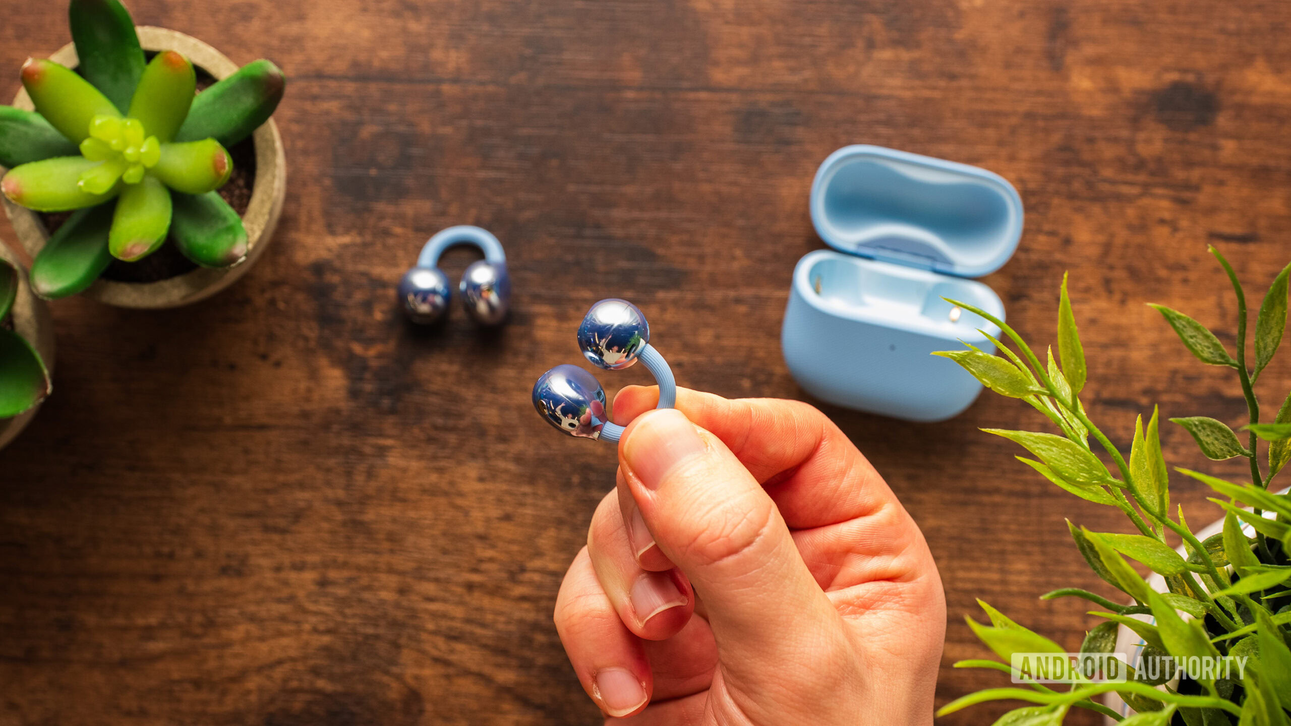 HUAWEI Free Clip 2 earbud held in hand.