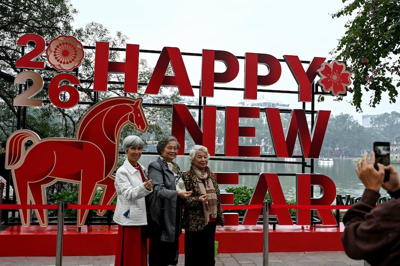 Women pose for photos by Hoan Kiem Lake next to a New Year installation in Hanoi, Vietnam. Photograph: Nhac Nguyen/Getty