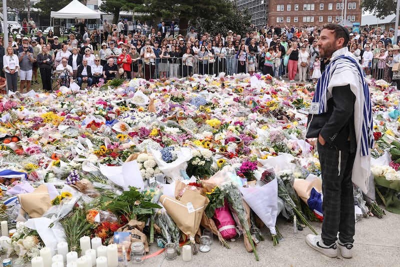 A rabbi speaks to mourners at a tribute outside Bondi Pavilion in Sydney. Photograph: David Gray/AFP 