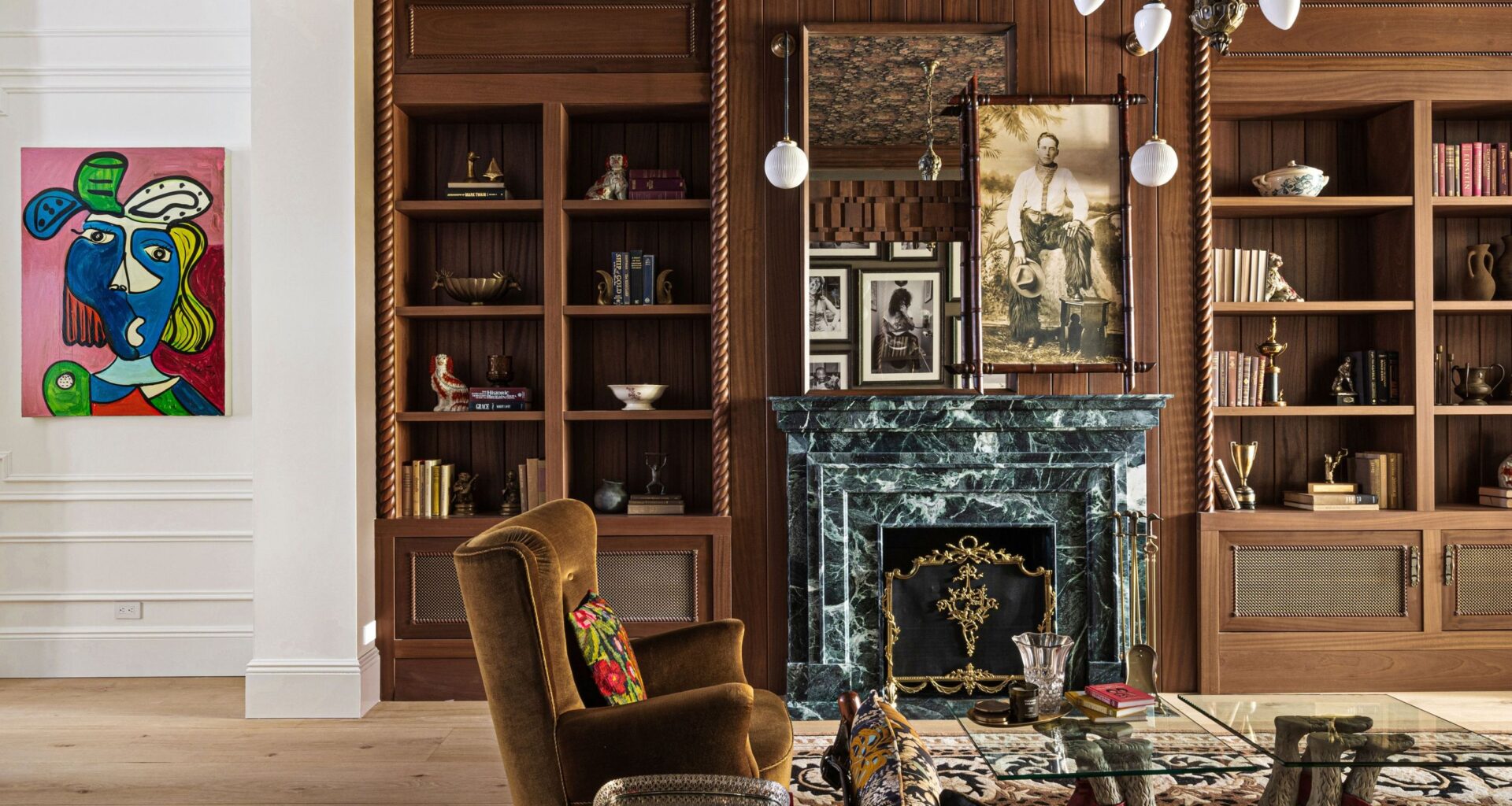 NYC parlor room featuring warm woods, a green marble fireplace, and contemporary artwork