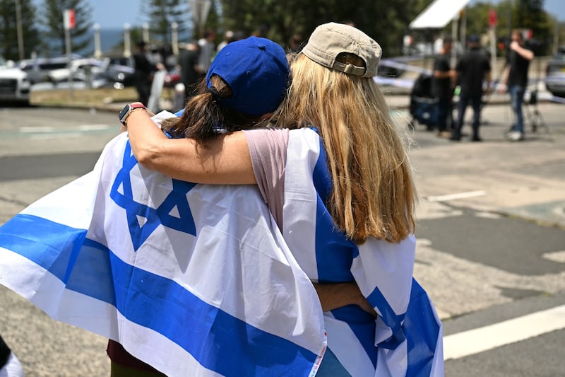 Members of the local Jewish community embrace at the Bondi Pavillion in memory of the victims of a mass shooting there. Photograph:  Saeed KHAN/AFP via Getty Images