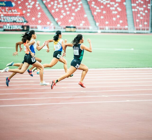 Women running a race on an athletics track