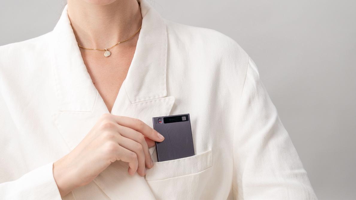 A press photo of a woman sliding a Mobvoi TicNote recorder into her shirt pocket.