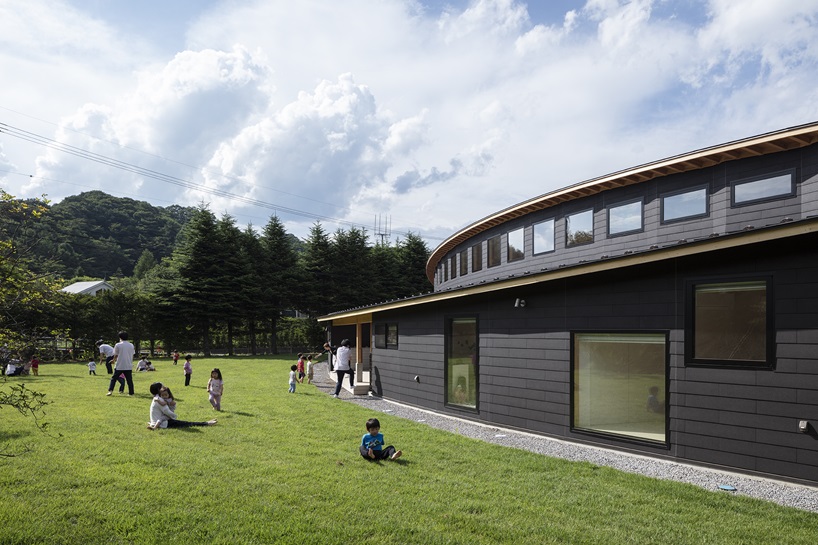 twin leaf-shaped roofs unfold atop nursery school by NIKKEN SEKKEI in japan