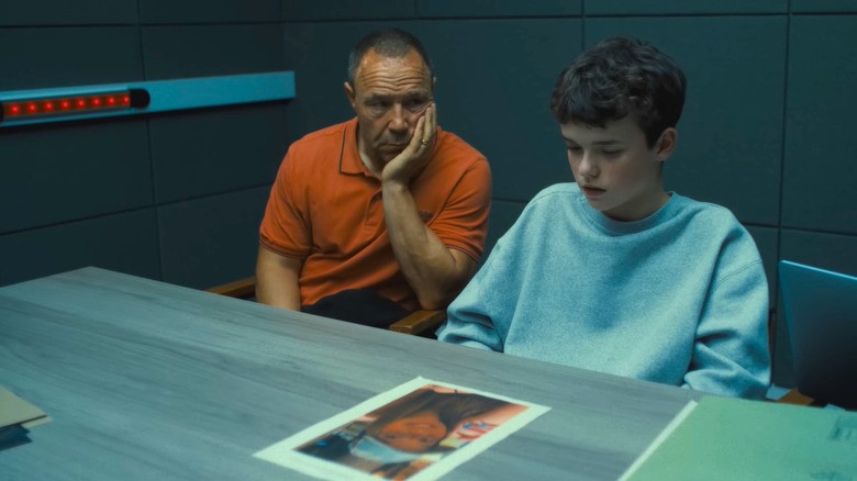 Stephen Graham as Eddie Miller and Owen Cooper as Jamie Miller, sitting in an interrogation room looking at an image of a girl in Adolescence