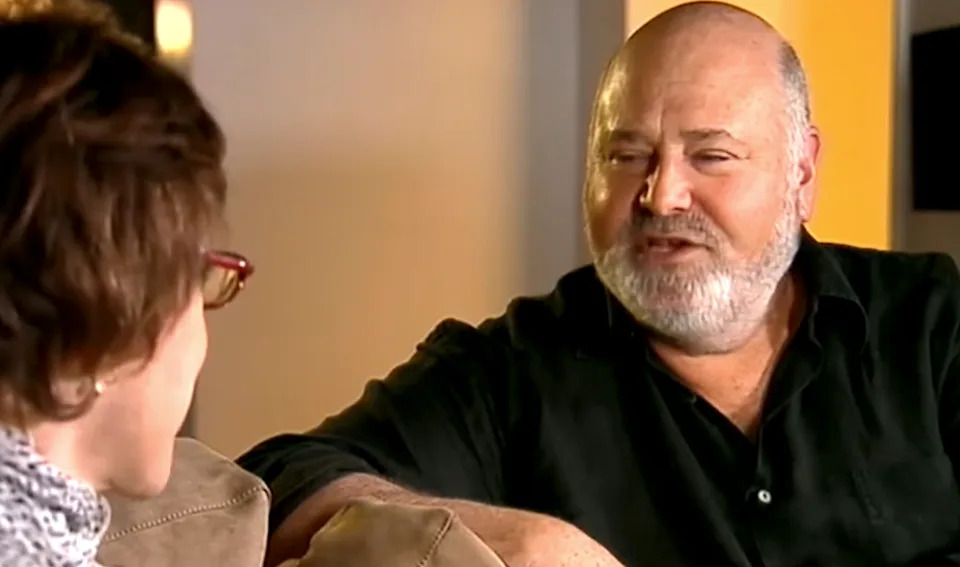 Two people sitting on a couch having a conversation in a casual setting