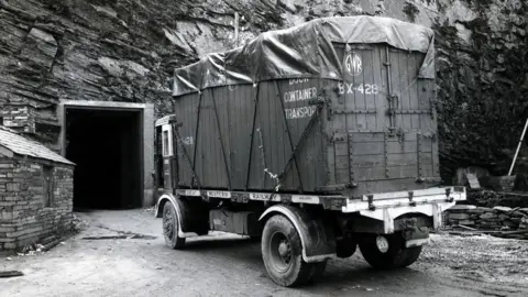 The National Gallery, London A black and white image of a container truck seen outside a door