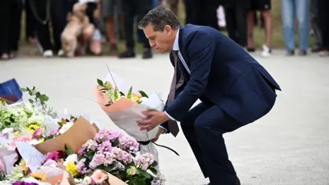 EPA NSW Minister for Health Ryan Park places flowers at a memorial at Bondi Beach
