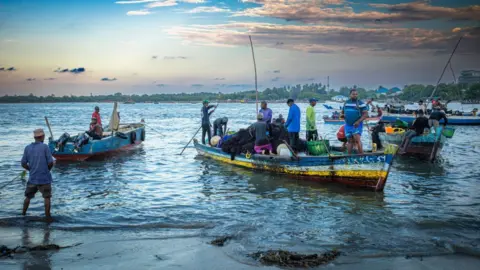 Universal Images Group via Getty Images Boats with people in them or on the shore in Dar es Salaam