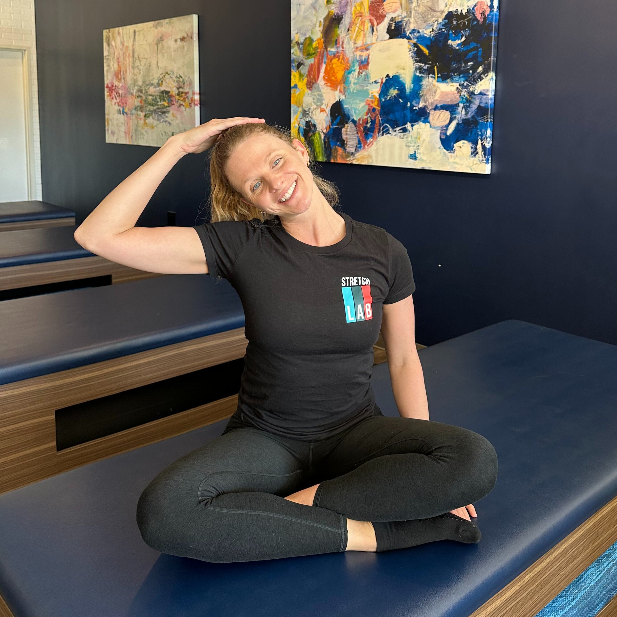 Woman demonstrates stretch in fitness studio